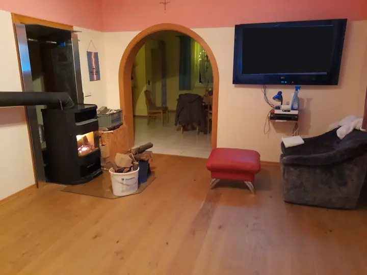 Wohnzimmer mit Schwedenofen und Rundbogen